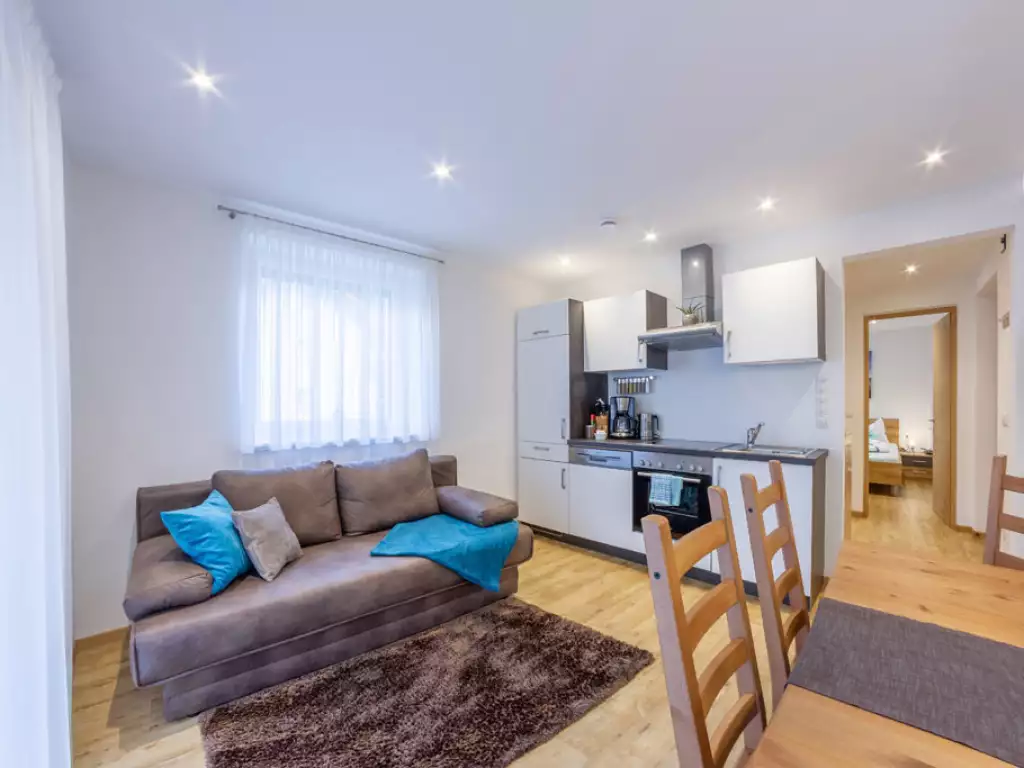 Das Bild zeigt unser Apartment 1 mit Wohnküche und Couch - Apartments Hubertus